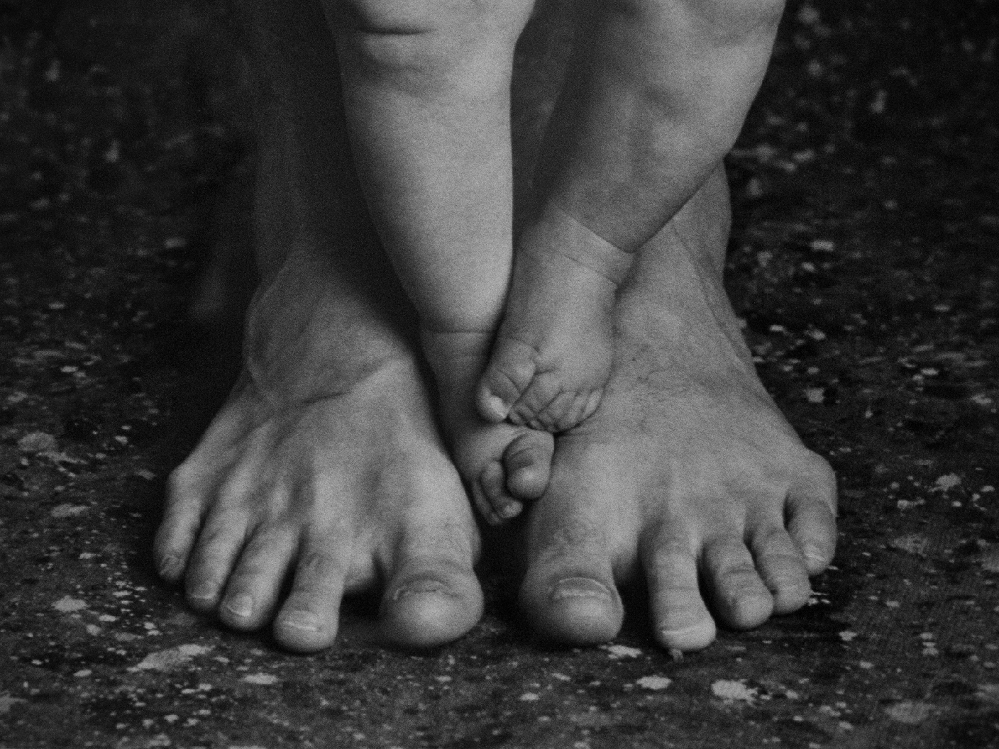 Adult feet and baby feet photographed together