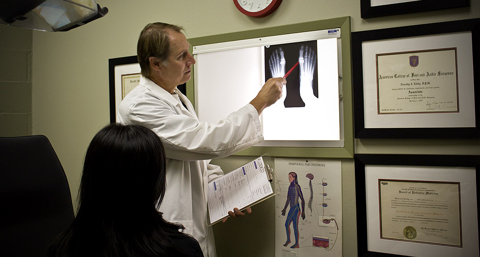 Dr. Timothy Liddy reviewing foot X-rays with a patient in the Beverly Hills office